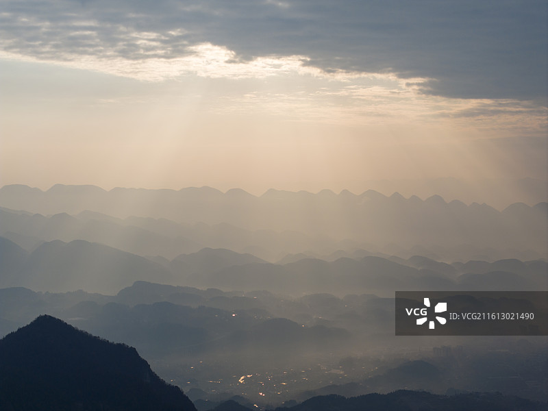 晨光穿透云层照耀山林，丁达尔光图片素材