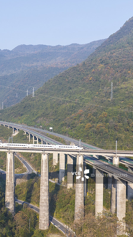一辆列车（动车）行驶在大山中宜万铁路和沪渝高速交汇处图片素材