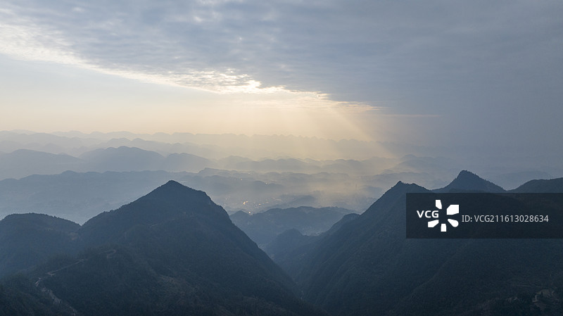 晨光穿透云层照耀山林，丁达尔光图片素材