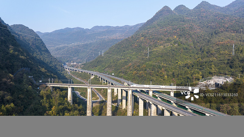 一辆列车（动车）行驶在大山中宜万铁路和沪渝高速交汇处图片素材