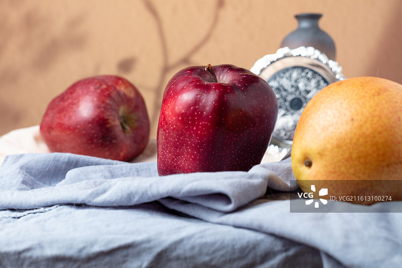 蓝布上摆放的新鲜花牛苹果图片素材