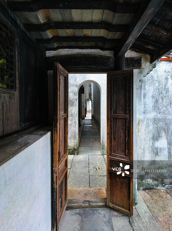 古宅木门虚掩，雕花格窗与石板庭院相映，江南的温婉从门里溜了出来图片素材