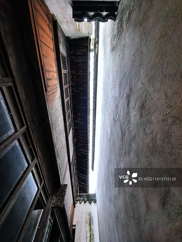 古宅木门虚掩，雕花格窗与石板庭院相映，江南的温婉从门里溜了出来图片素材