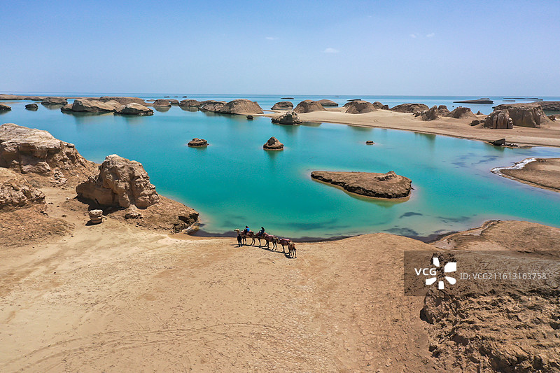 晴朗天空下行走的骆驼，水上雅丹图片素材