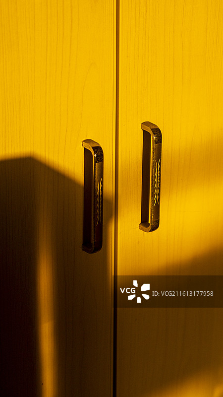 金色阳光洒进屋内橱柜门锁具把手光影特写图片素材