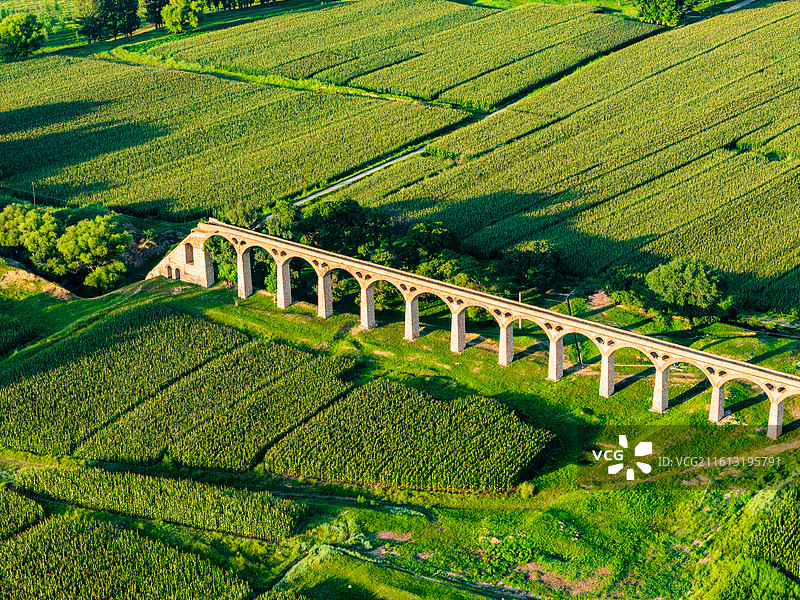 绿色田野上的古老水渠桥图片素材