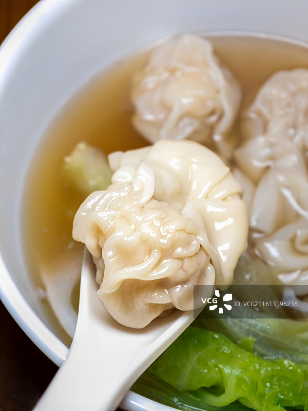 木质餐桌上一碗传统粤式鲜虾净云吞俯拍特写图片素材
