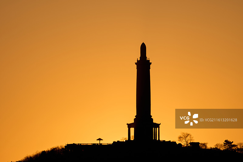 夕阳下橙色天空下的旅顺白玉山的轮廓图片素材