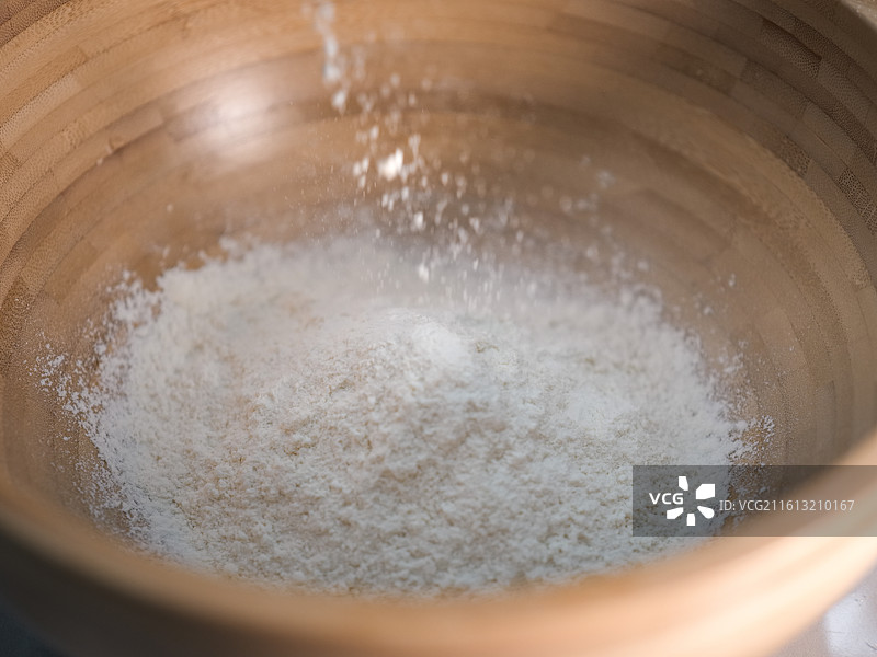 往木碗中的面粉里撒粉图片素材