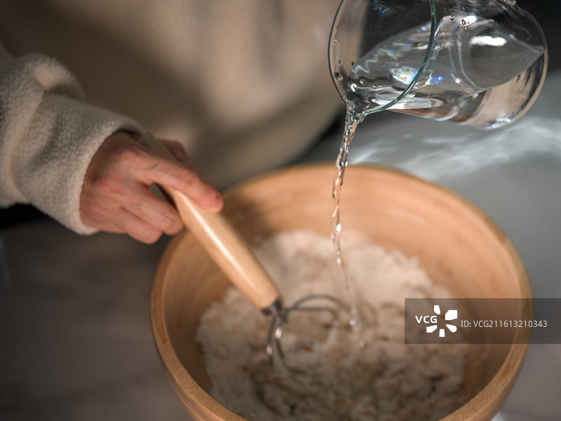 制作面食时加水搅拌的场景图片素材