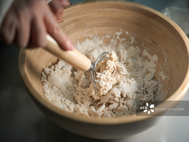 用搅拌器搅拌木碗中的面粉图片素材