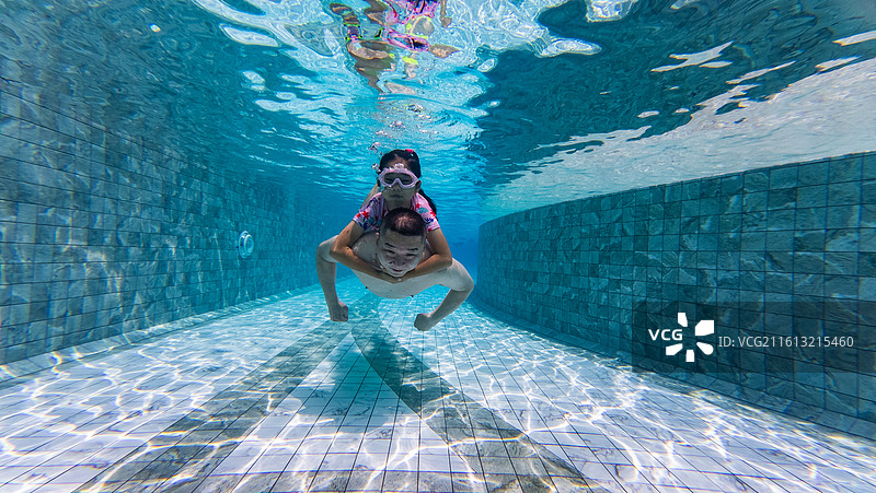 父亲和女儿在泳池潜水游泳图片素材