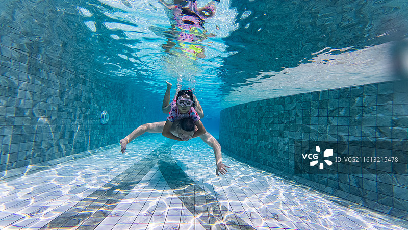 父亲和女儿在泳池潜水游泳图片素材