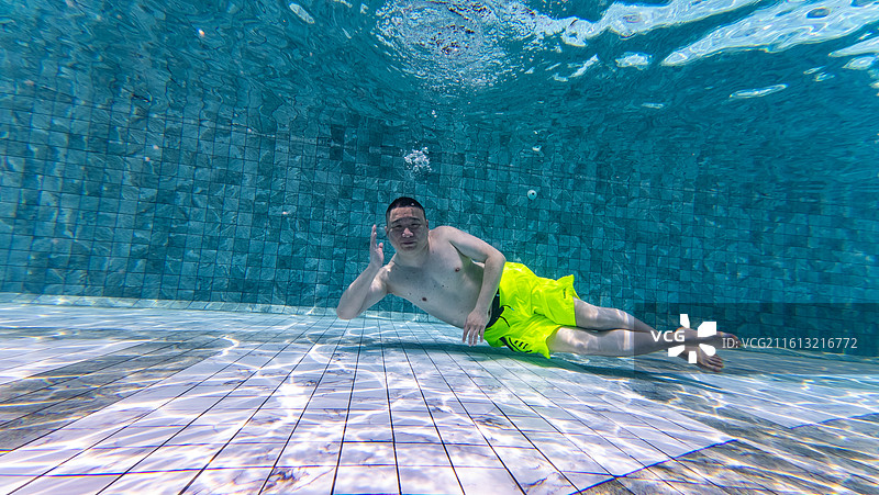 在泳池里游泳潜水的男人图片素材