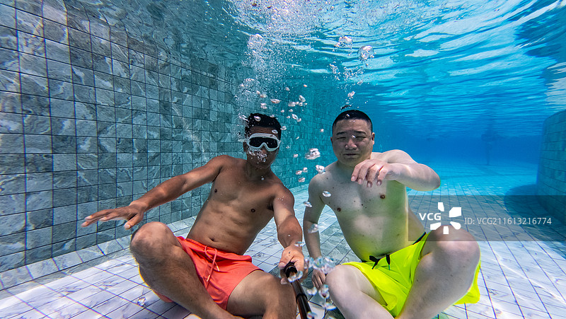 两个男人在游泳池里游泳潜水自拍图片素材