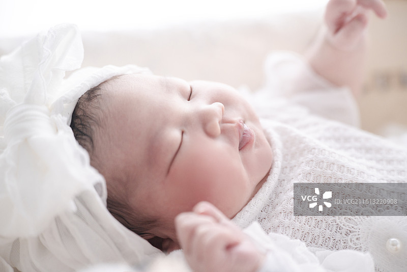 婴儿摇篮里甜梦中的新生女婴图片素材