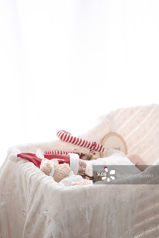 睡在摇篮里戴圣诞帽的新生女婴图片素材