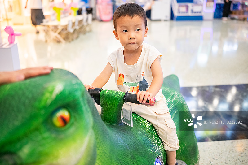和爸爸在广州正佳广场开恐龙车的小男孩图片素材