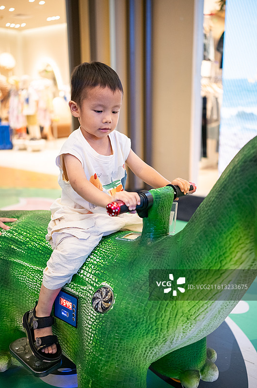和爸爸在广州正佳广场开恐龙车的小男孩图片素材