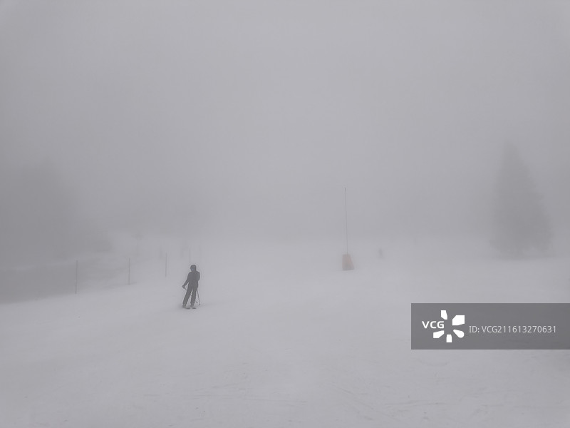 法国东南部阿尔卑斯山Chamrousse滑雪场，大雾中滑雪的人图片素材