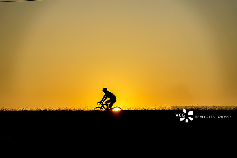 佛山三水北江大堤上的自行车者剪影图片素材