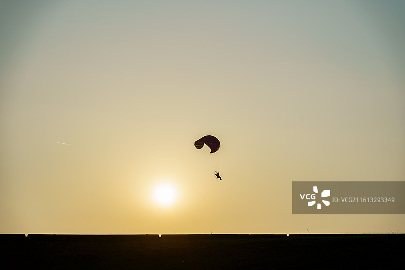 三水北江大堤上动力滑翔伞的剪影图片素材