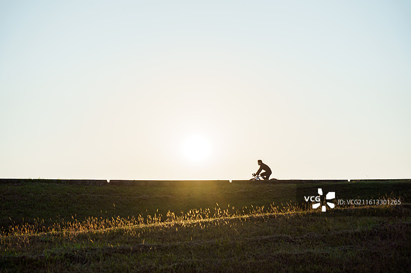 佛山三水北江大堤上的自行车者剪影图片素材