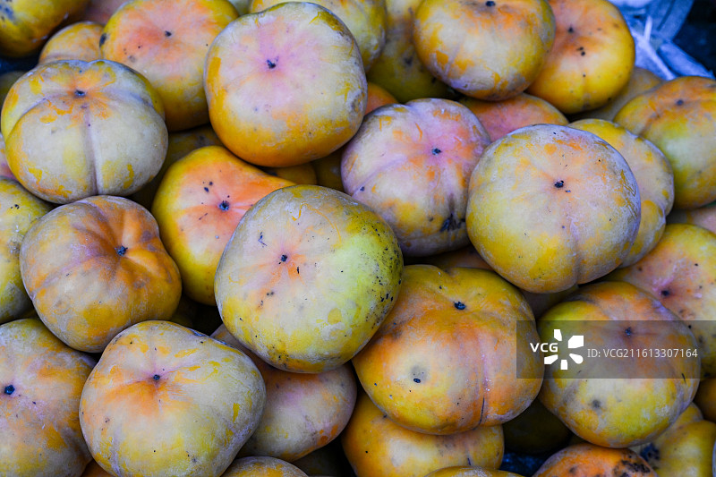 四川省绵阳市户外市场售卖新鲜的柿子图片素材