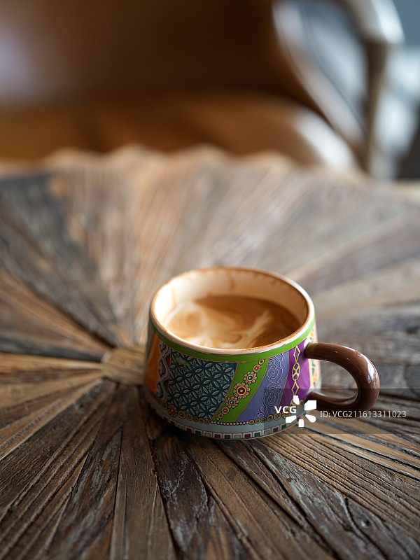 木桌上的彩绘咖啡杯图片素材