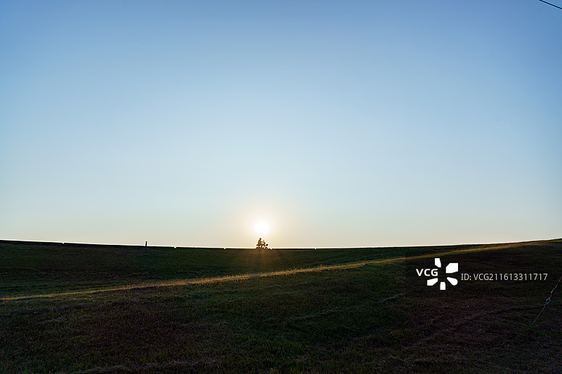 佛山三水北江大堤上的自行车者剪影图片素材