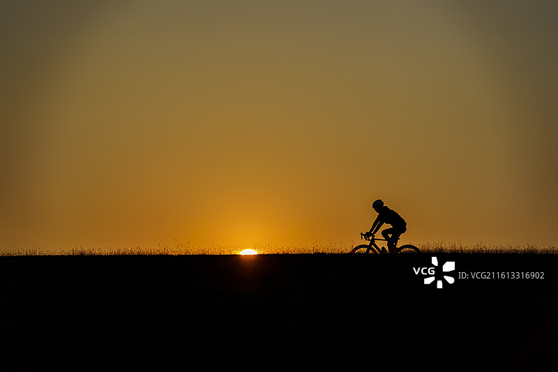佛山三水北江大堤上的自行车者剪影图片素材