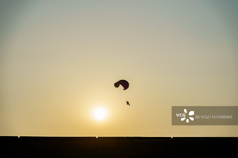 三水北江大堤上动力滑翔伞的剪影图片素材