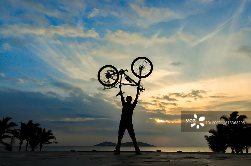 举起自行车的人物剪影图片素材