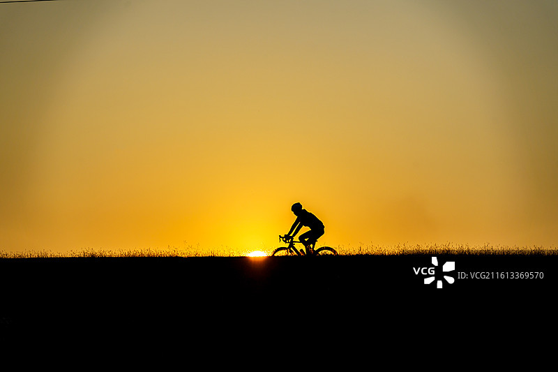 佛山三水北江大堤上的自行车者剪影图片素材