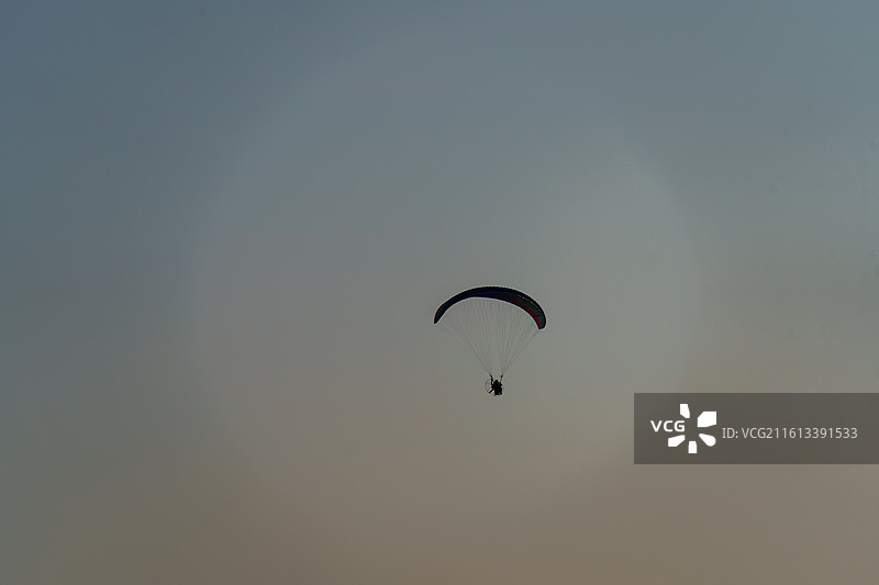 三水北江大堤上动力滑翔伞的剪影图片素材