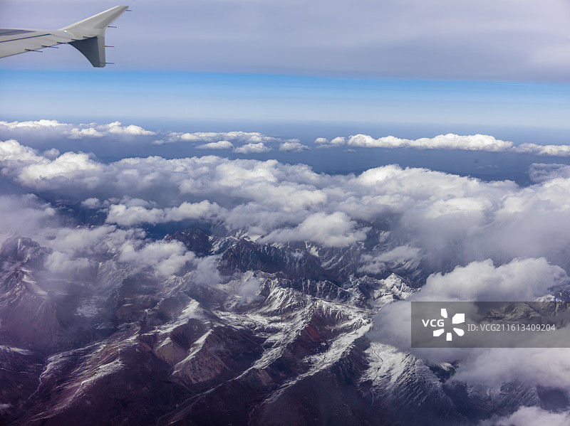 从兰州飞往张掖途中的震撼景象。画面中，连绵起伏的山脉覆盖着皑皑白雪，在阳光照耀下闪耀着圣洁的光芒。图片素材