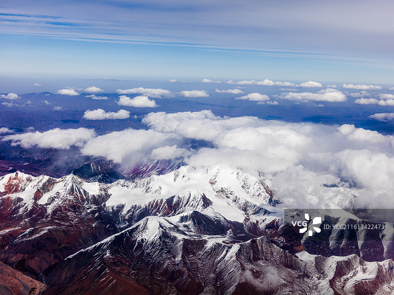 从兰州飞往张掖途中的震撼景象。画面中，连绵起伏的山脉覆盖着皑皑白雪，在阳光照耀下闪耀着圣洁的光芒。图片素材