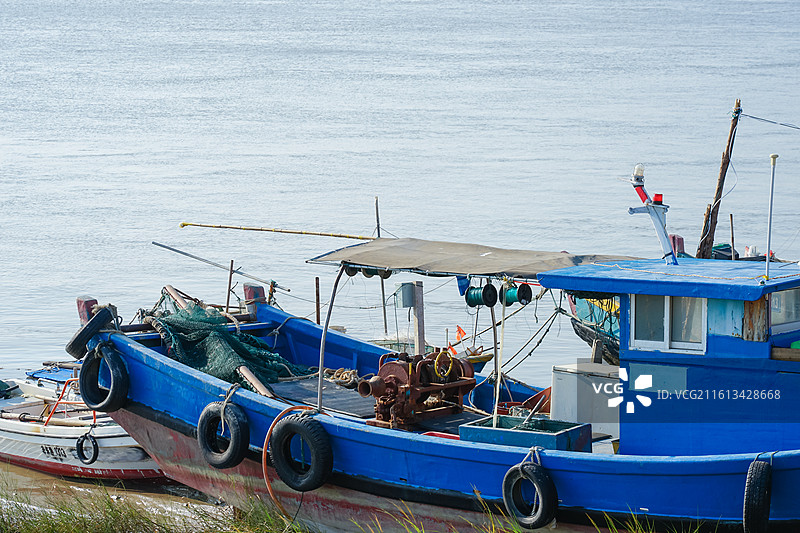 泉州蟳埔码头，蓝色渔船停泊在水边图片素材