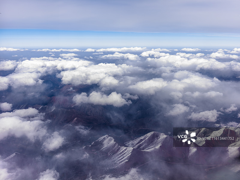 从兰州飞往张掖途中的震撼景象。画面中，连绵起伏的山脉覆盖着皑皑白雪，在阳光照耀下闪耀着圣洁的光芒。图片素材