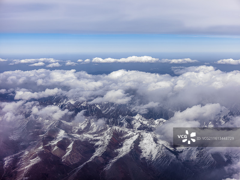 从兰州飞往张掖途中的震撼景象。画面中，连绵起伏的山脉覆盖着皑皑白雪，在阳光照耀下闪耀着圣洁的光芒。图片素材