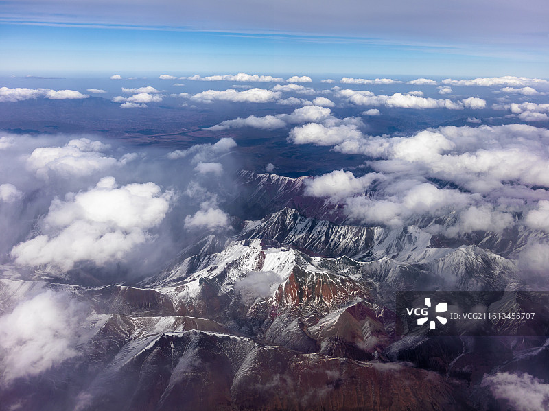 从兰州飞往张掖途中的震撼景象。画面中，连绵起伏的山脉覆盖着皑皑白雪，在阳光照耀下闪耀着圣洁的光芒。图片素材