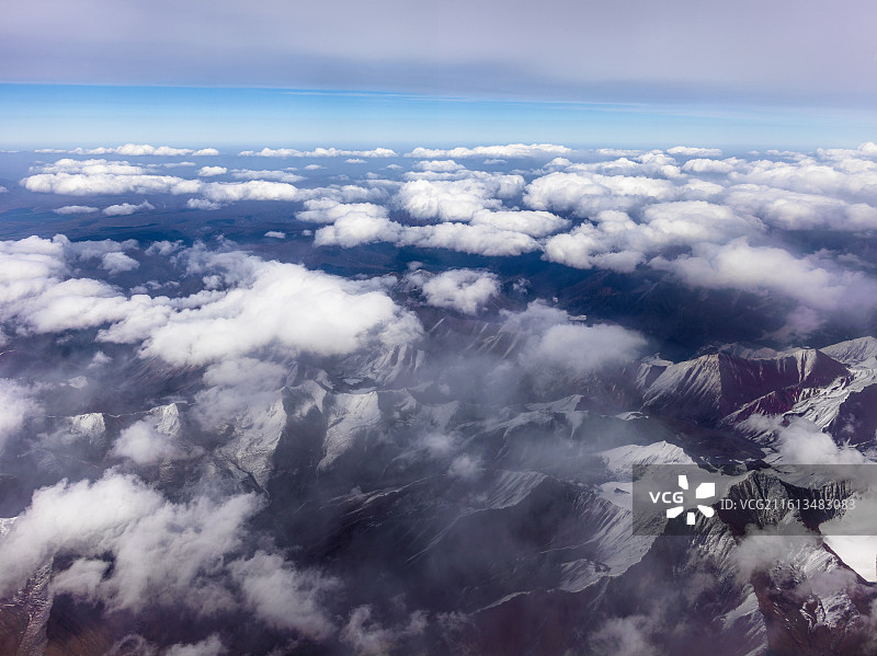 从兰州飞往张掖途中的震撼景象。画面中，连绵起伏的山脉覆盖着皑皑白雪，在阳光照耀下闪耀着圣洁的光芒。图片素材