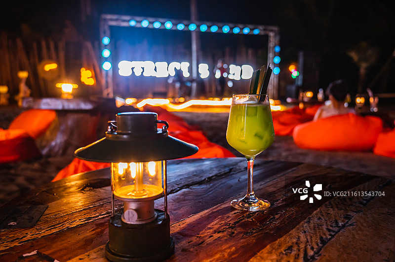 海滨沙滩吧夜间氛围特写：鸡尾酒与复古马灯图片素材