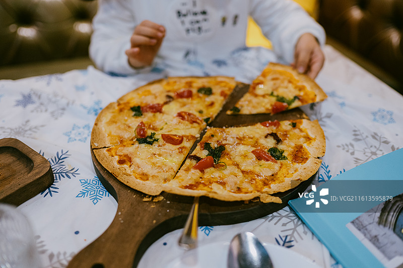 在餐桌上吃披萨的女人的中间部分图片素材