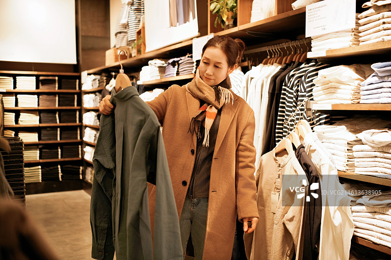 女士在时尚店选购外套图片素材