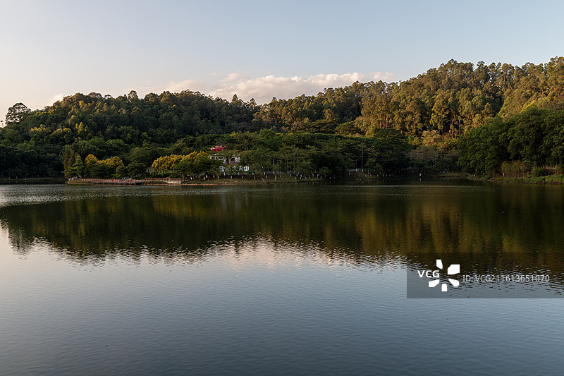 冬天夕阳下的广州大夫山森林公园木质栈道上红色的亭台楼阁与橙色落羽杉树木湖水中的倒影自然风光图片素材
