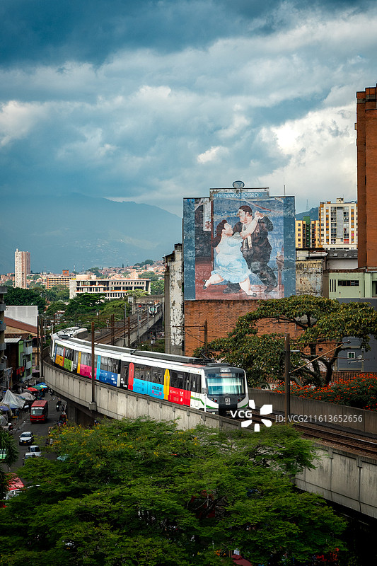 哥伦比亚麦德林城市风光：彩色轻轨地铁与博特罗艺术壁画图片素材
