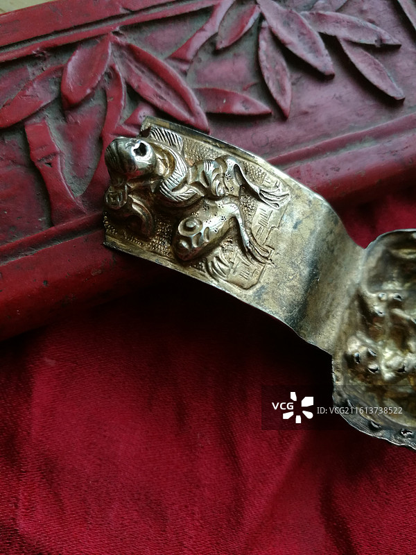 红色老绣花品片背景传统老银首饰品。人物发簪子残件图片素材