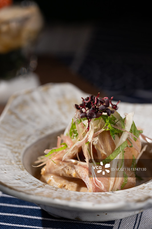 瓷碗中搭配胡麻酱的油甘鱼刺身前菜，点缀以新鲜茗荷与大叶。图片素材