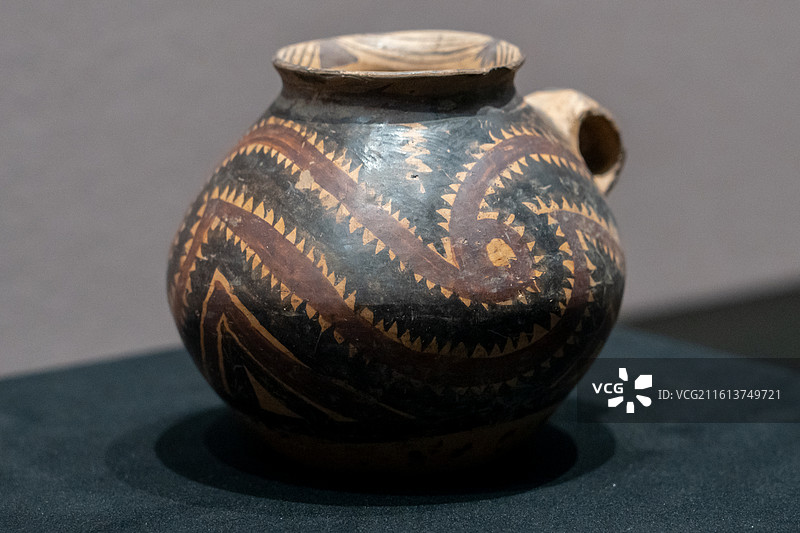 甘肃省博物馆藏，半山类型漩涡纹锯齿纹单耳彩陶罐图片素材